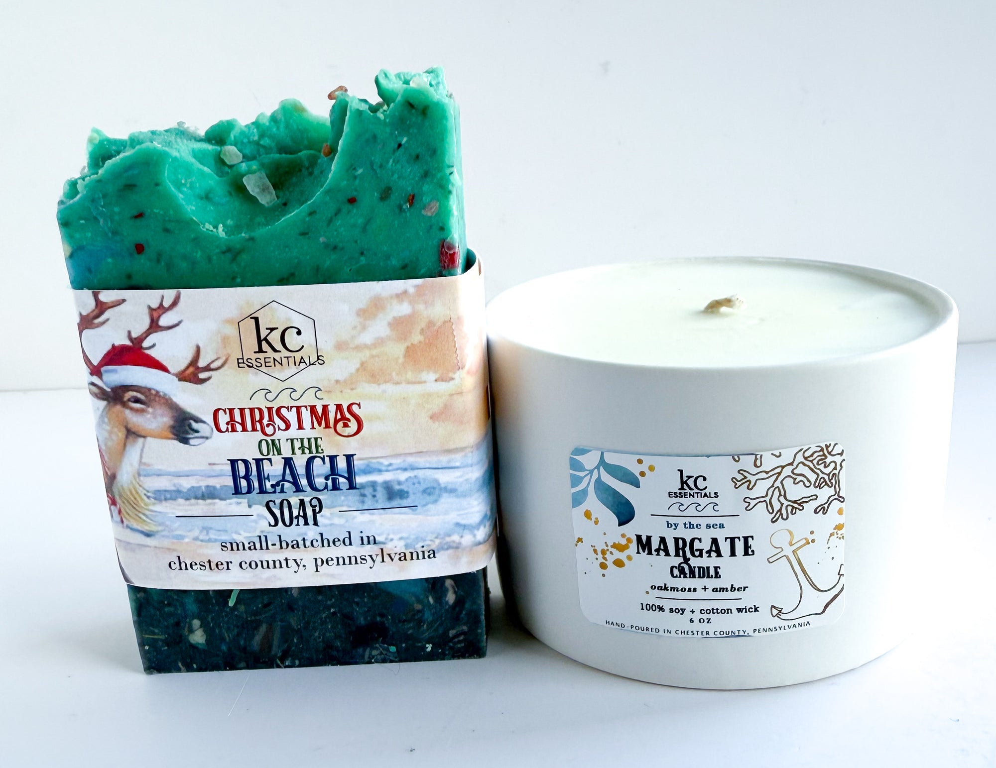Green soap bar with 'Christmas on the Beach' packaging and a white candle labeled 'Margate' on a white background. Beach christmas soap and candle set, margate new jersey shore, beach soap and candle, sea soap